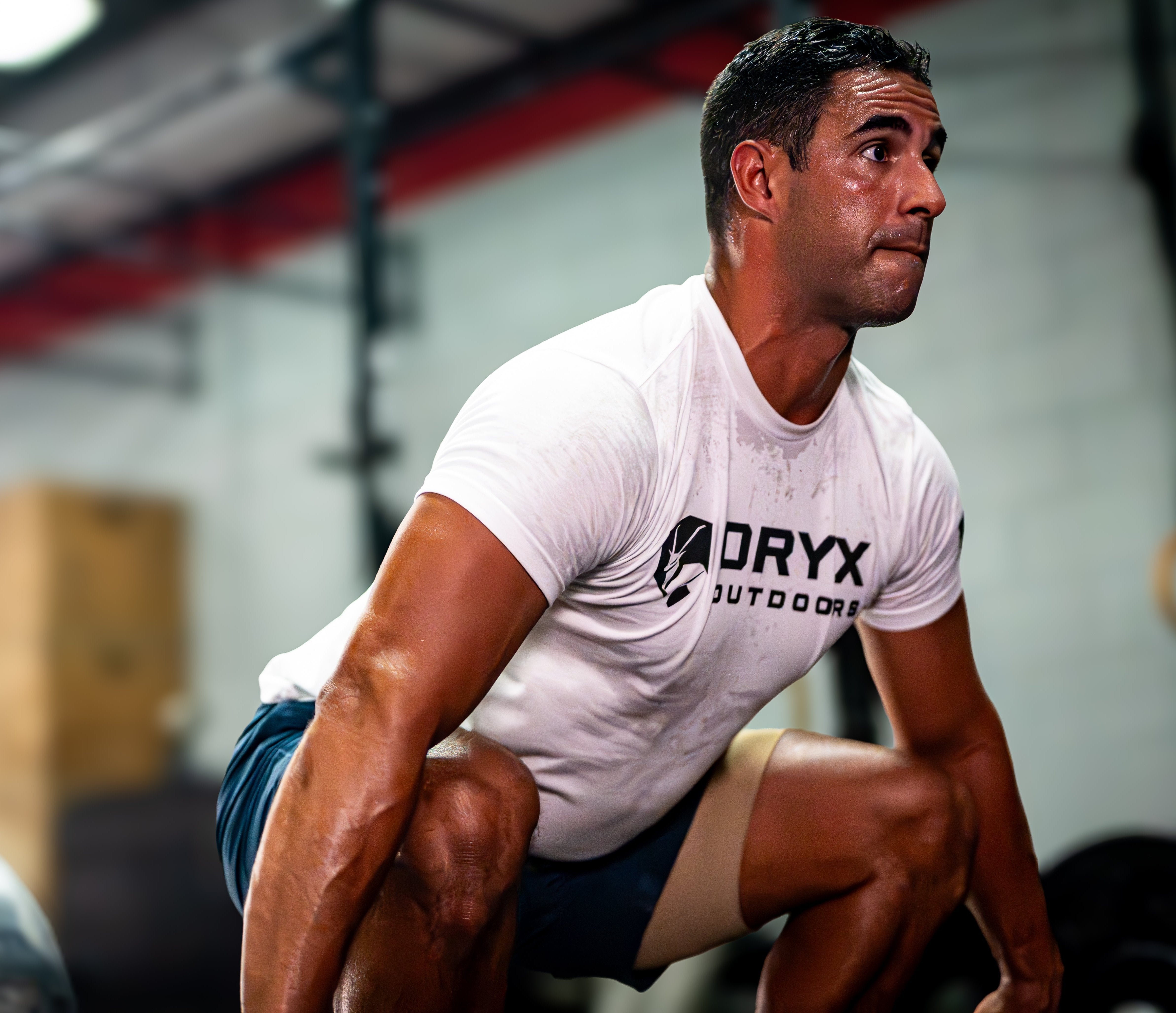 man deadlifting in blue/tan training short and oryx outdoors branded t-shirt